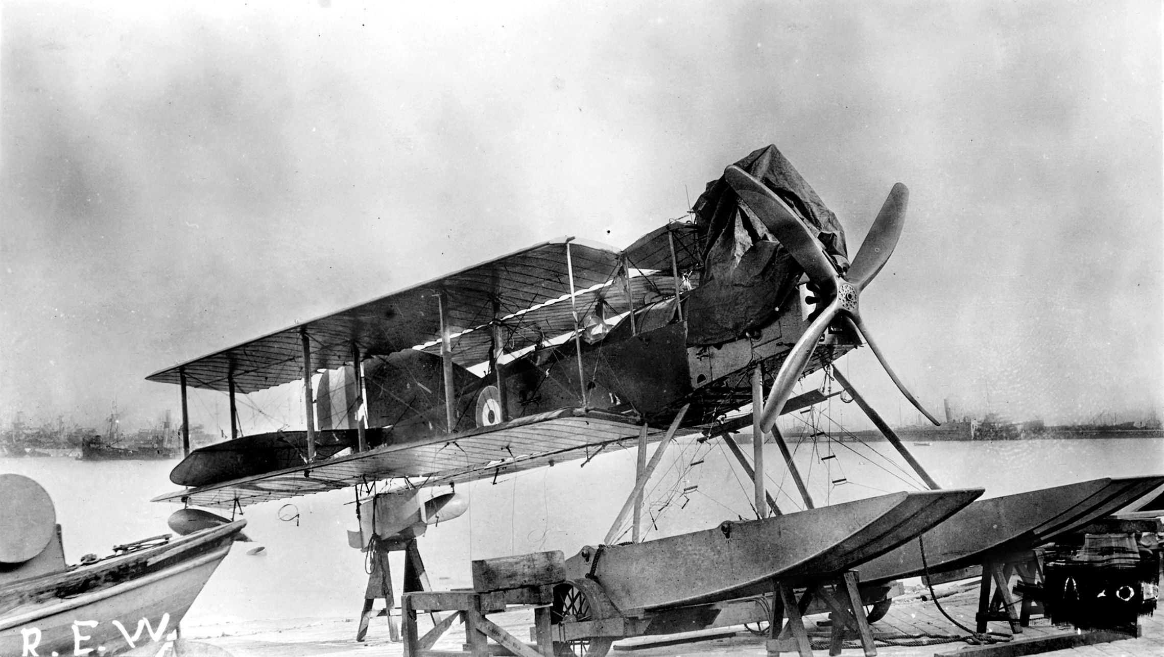 Most likely a Royal Naval Air Service Short Type 184 Folder seaplane with wings folded for storage on a carrier ship. These planes were carried on conventional ships fitted with canvas or, later, steel hangars and winched in and out of the water for take off and landing. 