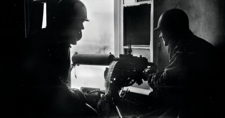 GIs fire a water-cooled M1917 Browning machine gun from the window of a house during the Battle of the Bulge in December 1944. The 3rd Battalion, 110th Infantry Regiment, delayed the Germans for a critical 36 hours at Hosingen, Luxembourg.