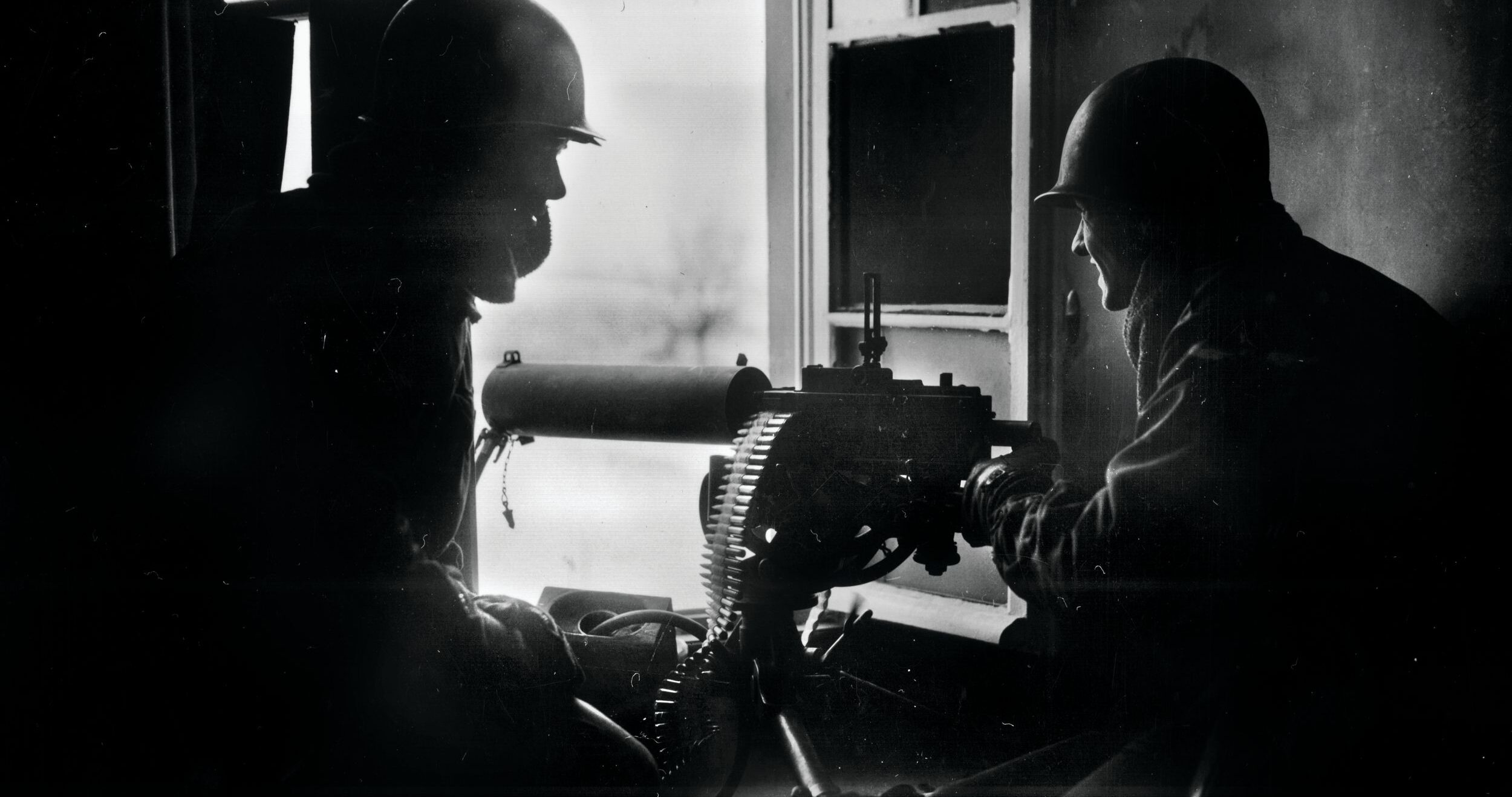 GIs fire a water-cooled M1917 Browning machine gun from the window of a house during the Battle of the Bulge in December 1944. The 3rd Battalion, 110th Infantry Regiment, delayed the Germans for a critical 36 hours at Hosingen, Luxembourg.