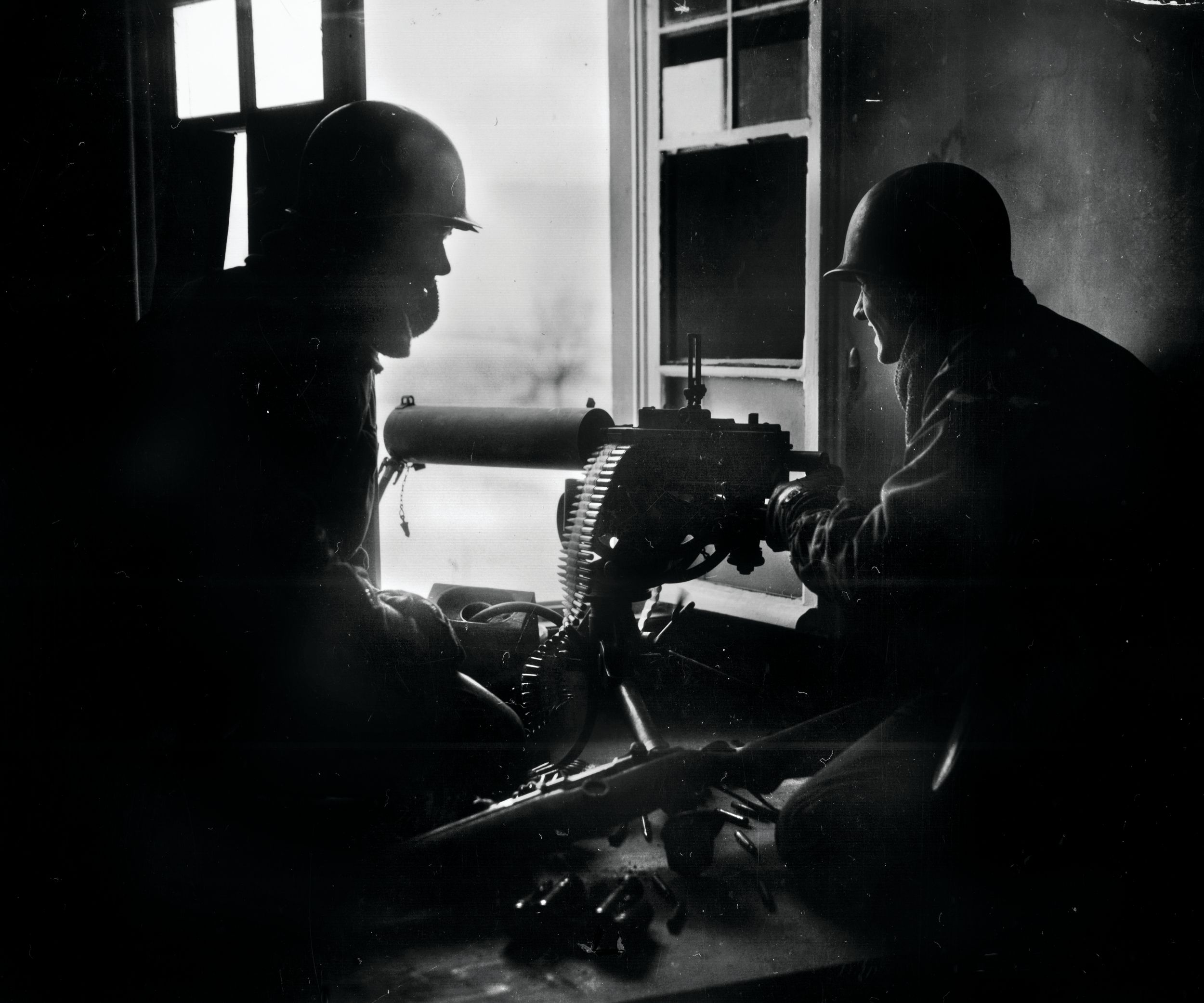 GIs fire a water-cooled M1917 Browning machine gun from the window of a house during the Battle of the Bulge in December 1944. The 3rd Battalion, 110th Infantry Regiment, delayed the Germans for a critical 36 hours at Hosingen, Luxembourg.