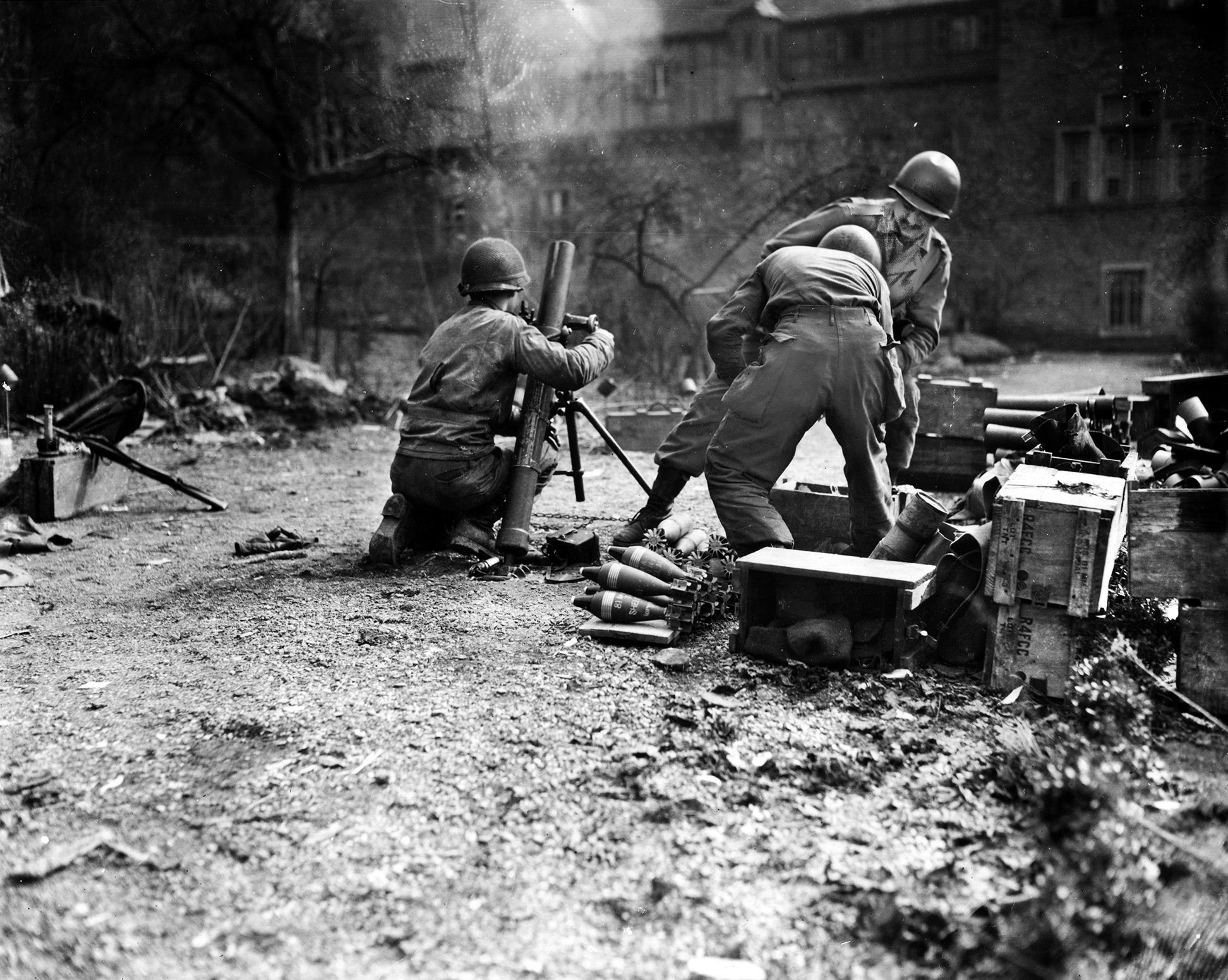 A 60mm mortar team unleashes a high-angle volley against advancing German elements near the border with Luxembourg. Despite being dangerously low on supplies during the opening salvos of the massive Ardennes Offensive, the U.S. Army’s 110th Infantry Regiment (28th ID) in Hosingen repulsed the initial German assaults, stalling the enemy’s drive toward Bastogne for 36 hours before surrendering.