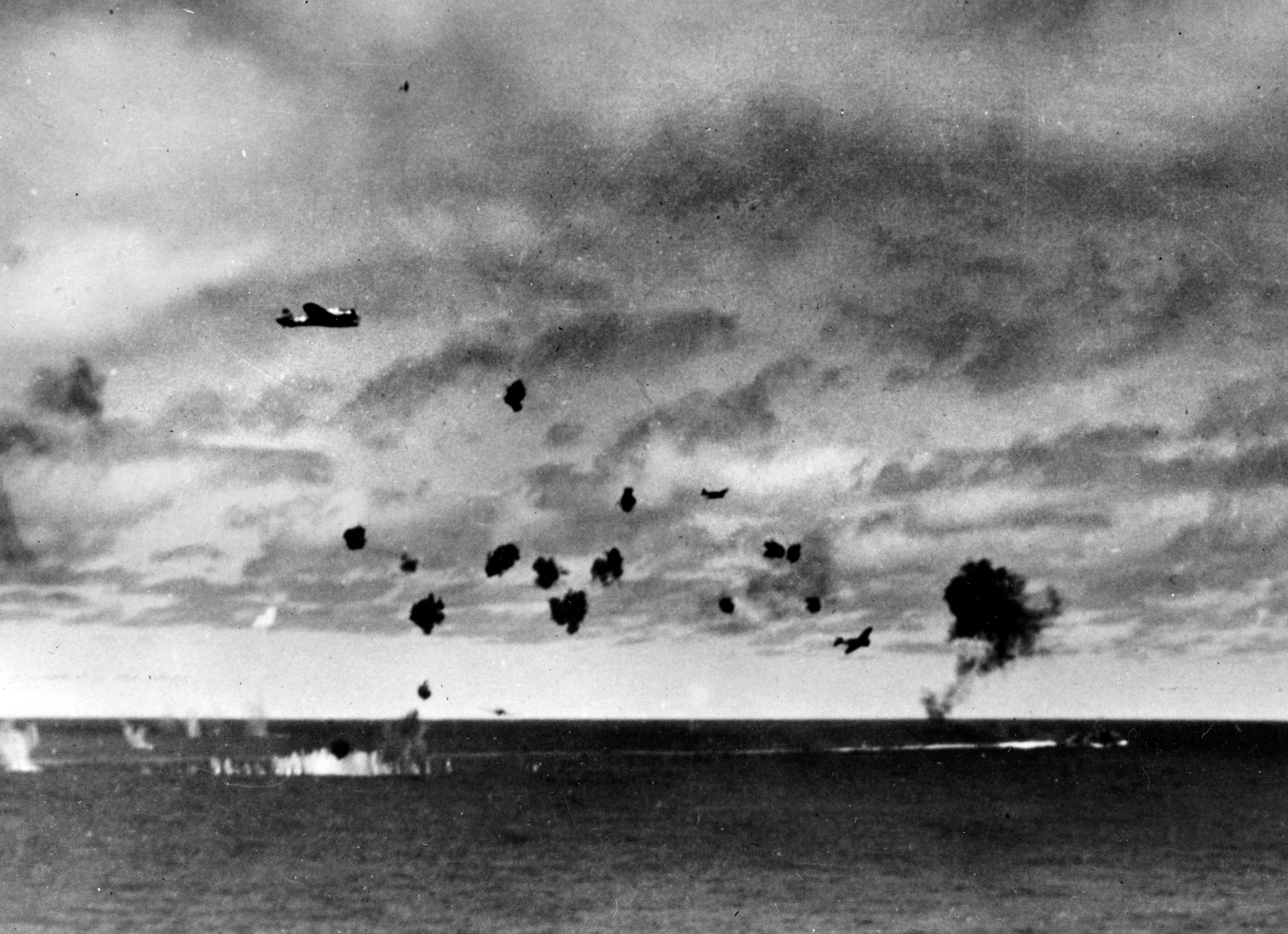 Flying through a heavy cloud of American antiaircraft fire, Japanese Type 97 “Kate” torpedo bombers from Hiryu—the lone surviving Japanese carrier—attack USS Yorktown in mid-afternoon during the Battle of Mid- way on June 4, 1942. The lead plane (upper left) has already dropped its torpedo, while two others (lower right) pull away. On the right-center horizon, a dark plume of smoke marks where a Japanese plane crashed into the sea.