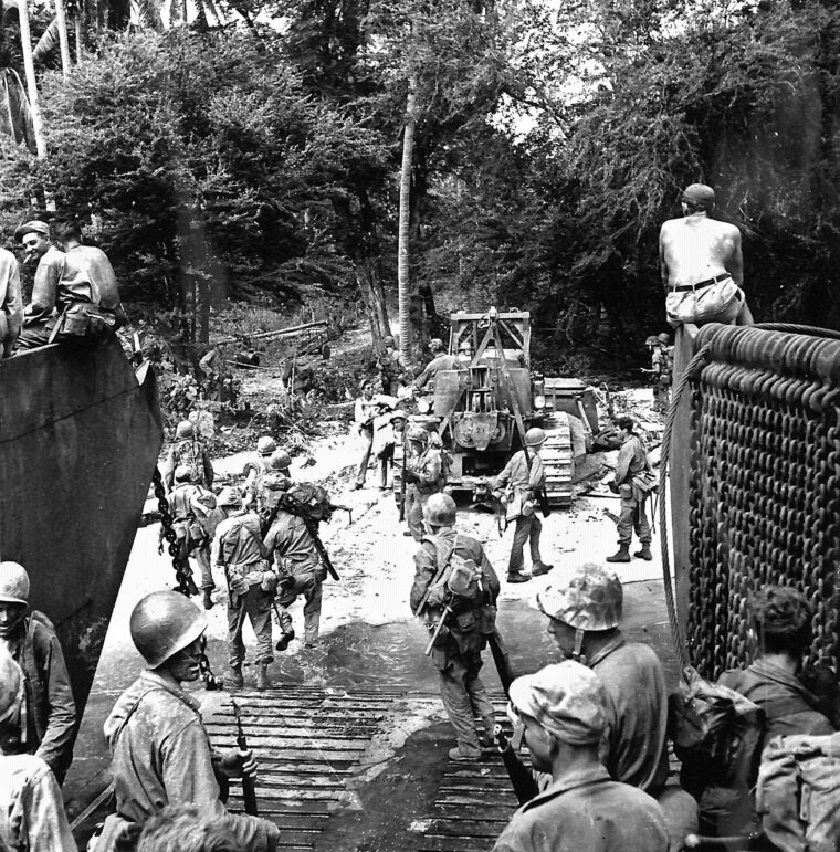 GIs use a bulldozer as a shield against potential sniper fire as they move off a Luzon beach in March 1945. For the infantry, every landing in the Philippines had its own perils. Arriving on the island with the 27th Infantry Regiment, Sgt. Joe Sciarra stepped off the ramp of his landing craft with nearly 100 pounds of weapons and gear—and sank over his head in an underwater crater, before managing to scramble up to the safety of the beach.