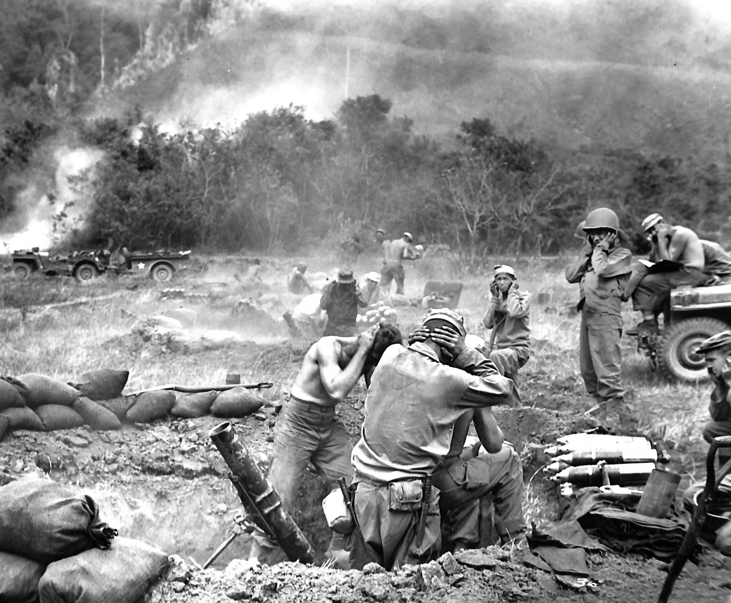 A 25th Infantry Division mortar team hammers Japanese strongpoints during the rugged mountain campaign on Luzon, March 1945. While military guidelines called for a deep 4x4x4-foot dug-in position to safeguard the men and stabilize the weapon, unyielding rocky soil or the urgent need to suppress incoming artillery meant crews sometimes had to compromise on depth, as seen in this hastily dug emplacement.