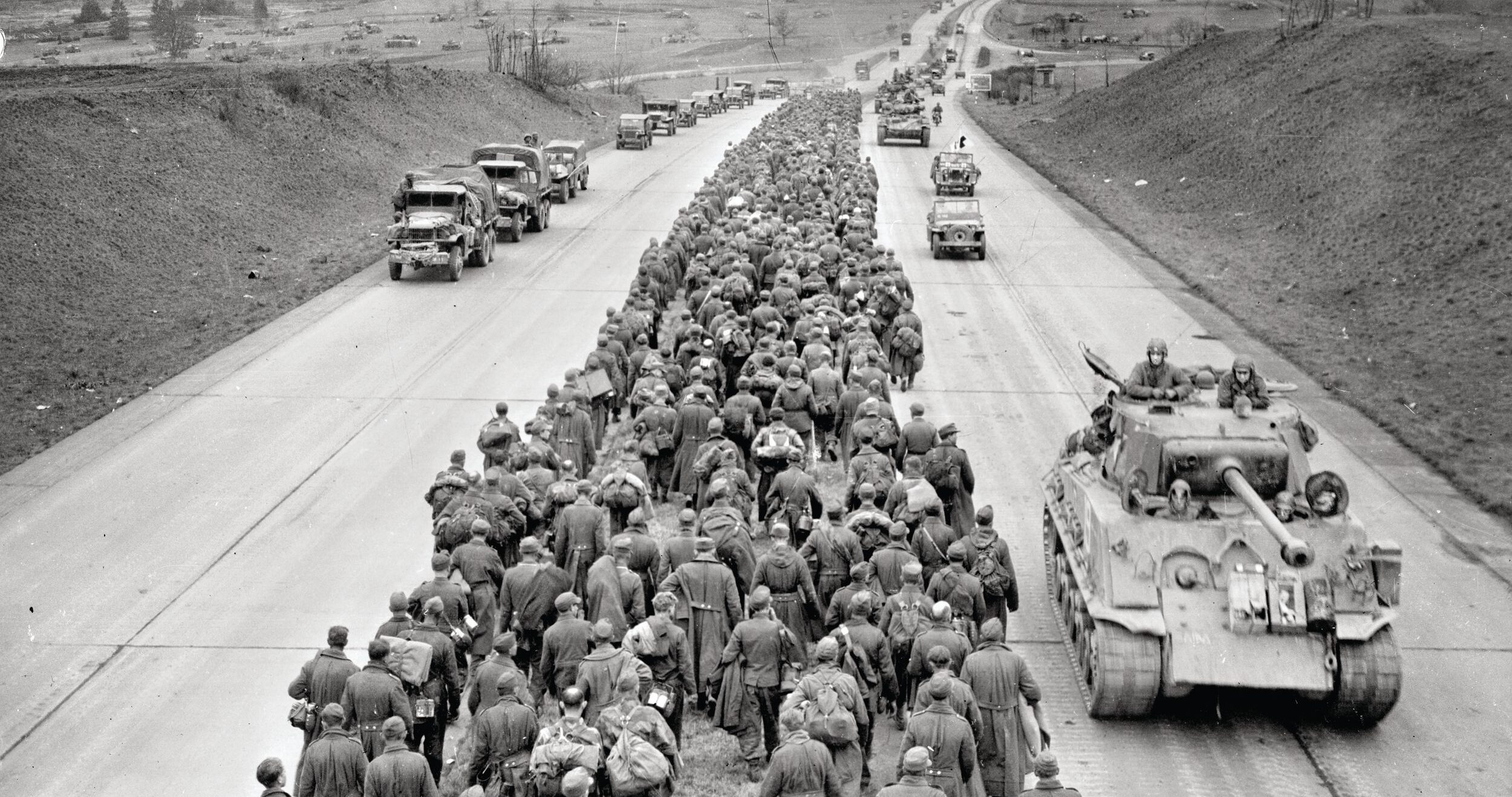 German POWs marching west fill the median of the Autobahn near Giessen as tankers from the U.S. 6th Armored Division roll east. Once across the river, Patton’s army spent the next two months barreling across Germany and would end the war in Austria and Czechoslovakia. OPPOSITE: Patton thanks his engineers for their speed in erecting a bridge across the Rhine River, the last natural barrier to invading the Third Reich.
