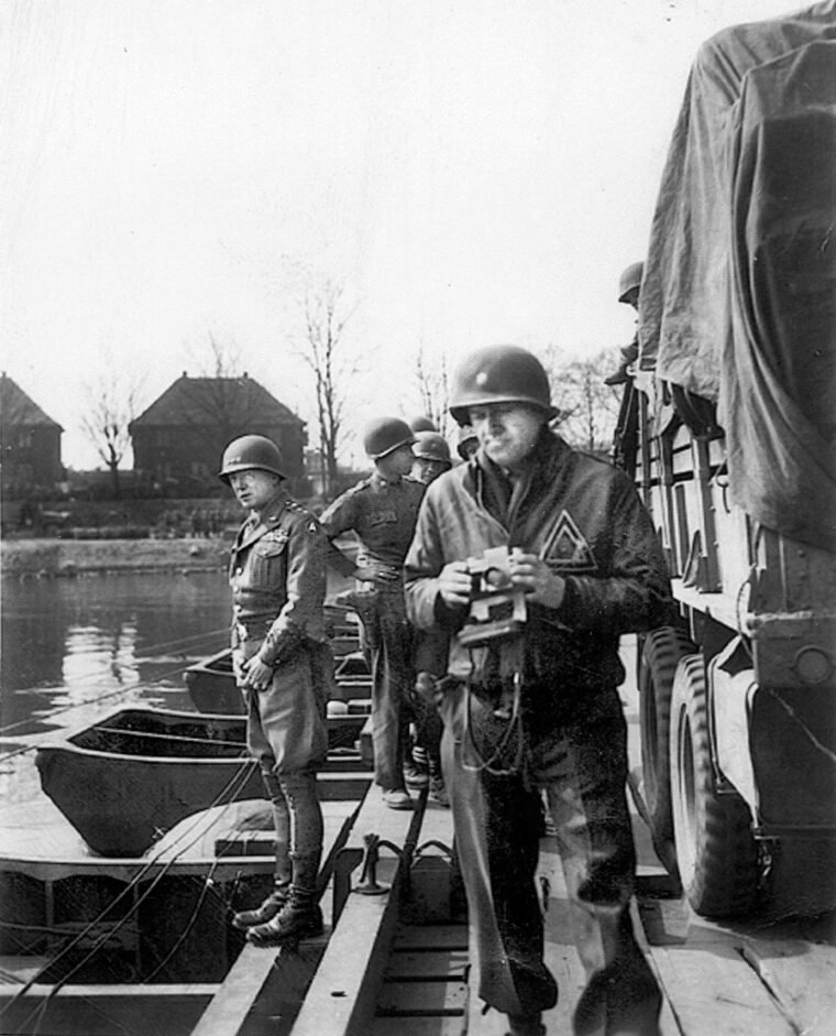 Patton christens the Rhine River. His aide, Col. Charles Codman walks away from the general, having taken a much more family-appropriate photograph. Patton had been hoping to reach the river eight months earlier, in August of 1944, and took joy in briefly relieving himself in the river.