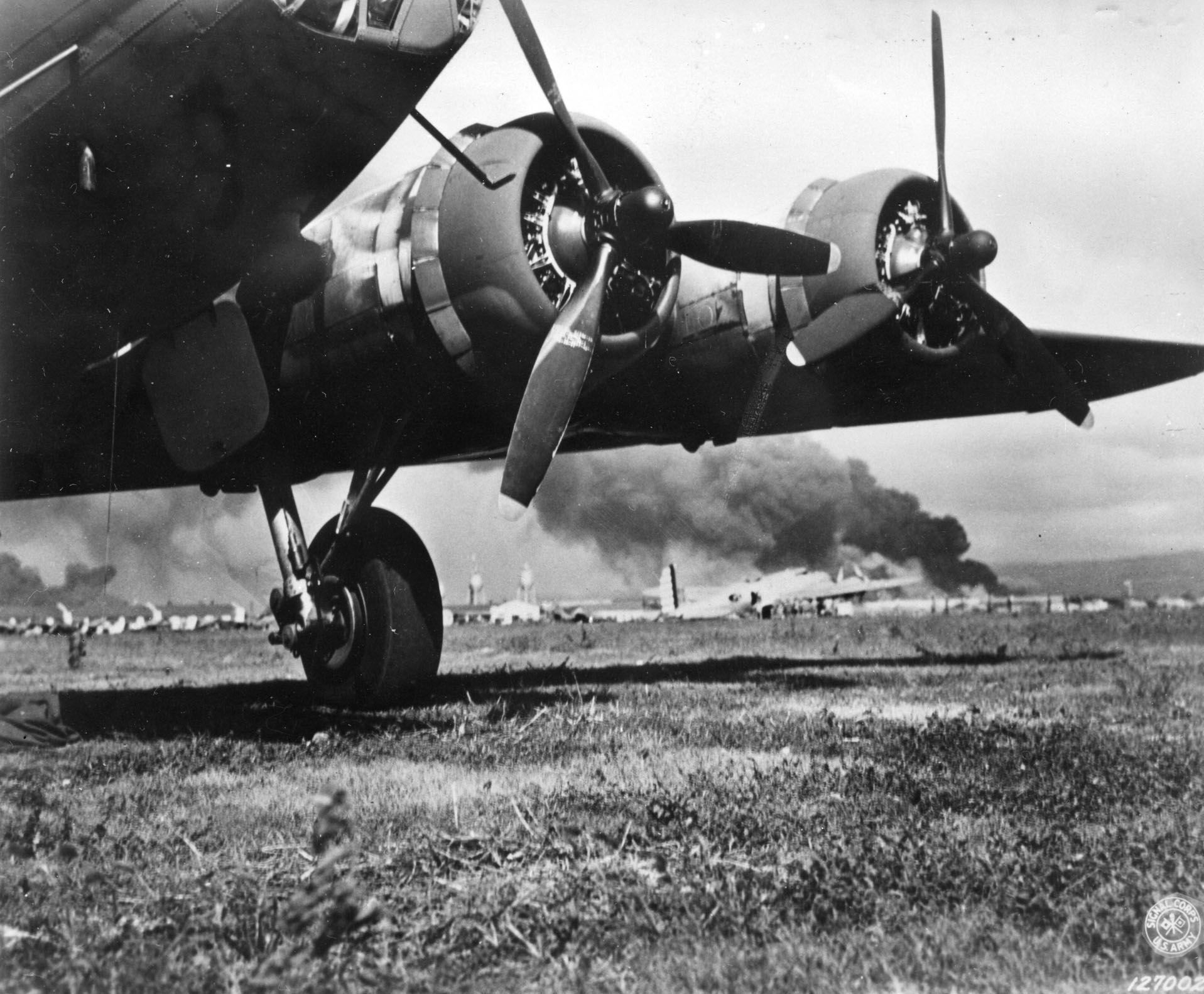 A flight of Boeing B-17 Flying Fortress bombers arriving from California was caught in the midst of the Japanese attack on Pearl Harbor. Several of the planes sustained serious damage or were destroyed. This photo taken at Hickam Field shows at least two of the bombers after their landing.