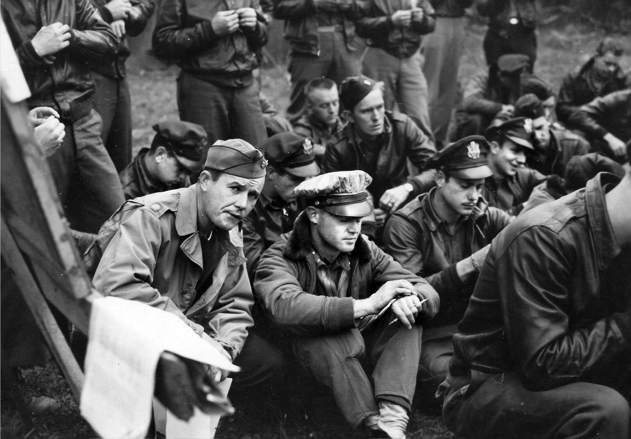 Lieutenant Colonel Bruce F. Parcell, CO of the 510th Fighter Squadron (seated, center), and his pilots “hack” their watches during a pre-mission briefing. Synchronized timepieces were necessary to coordinate complex dive-bombing runs, execute precise rendezvous with Allied ground forces, and avoid deadly anti-aircraft batteries. On July 27, 1944, during a strafing run at 200 feet against a German convoy between Coutances and Saint-Lô, Parcell was injured and his P-47, Little Lulu, was heavily damaged by flak. Unable to bail out, Parcell died instantly in the explosion when his plane crashed.