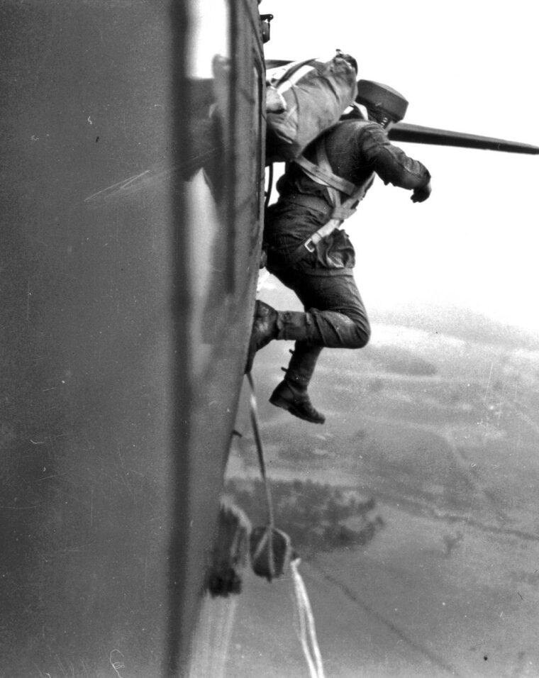 During a pre-invasion training jump over England, a Canadian paratrooper jumps out of a Douglas C-47 Dakota, the workhorse of Allied airborne operations. The troopers trained endlessly to exit the aircraft’s port-side troop door at intervals of less than a second apart, to prevent the unit from scattering across miles of countryside upon hitting the ground.
