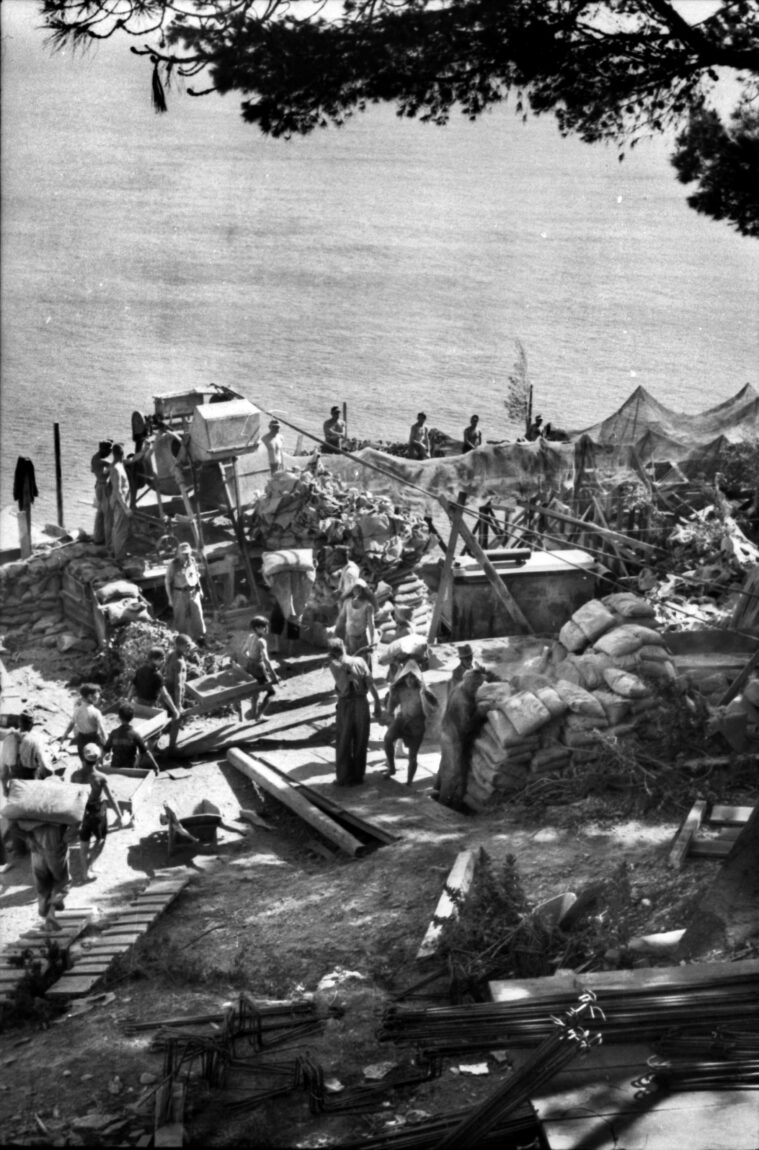 Germans, and conscripted Italian workers, construct fortifications beneath camouflage netting on the Ligurian coast.