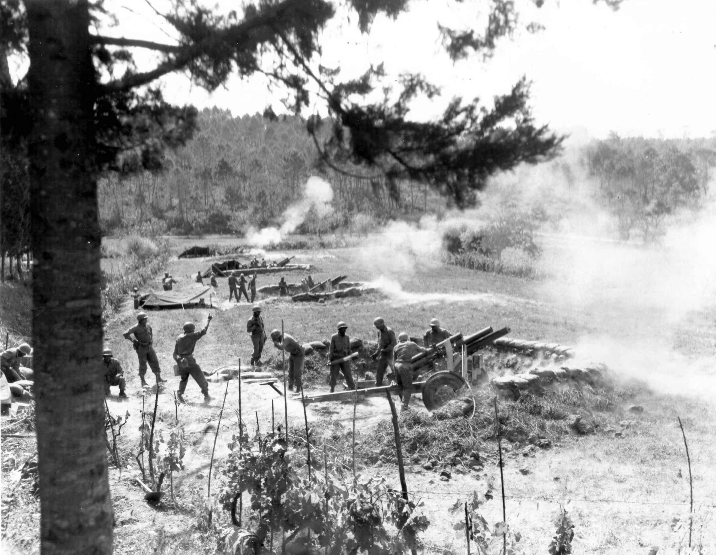 The first African American artillery unit in the Italian theater fires its 105s at German positions across the Arno River, August 29, 1944.