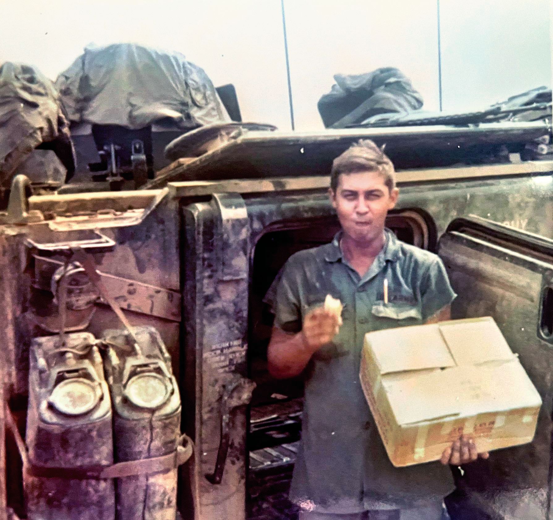 Just after receiving a package of cookies baked by his mother, Spc. 4th Class Kenneth Crowell Jr. (2nd Platoon, H Troop, 17th Cavalry) stands beside his M113 armored personnel carrier at Landing Zone Bayonet, Chu Lai, South Vietnam, in October 1968.