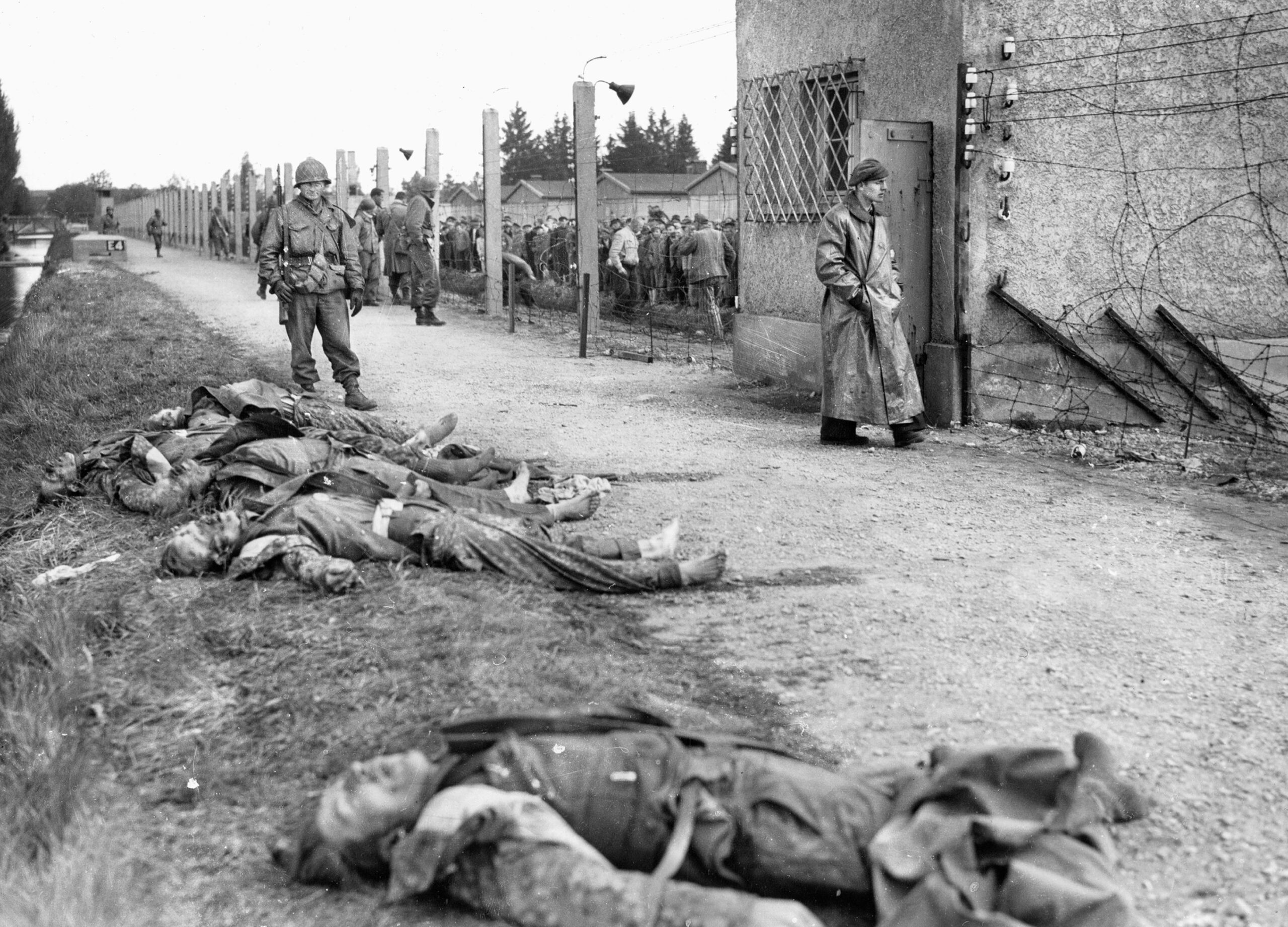 The bodies of SS guards lie next to a concrete moat surrounding the prisoner enclosure at the Dachau concentration camp following its liberation on April 29, 1945. The takeover of the camp was marked by intense chaos and retaliation as several guards were killed in initial firefights with advancing U.S. troops, others were shot or executed during the confusion of the surrender, and some were killed by liberated inmates in retribution.