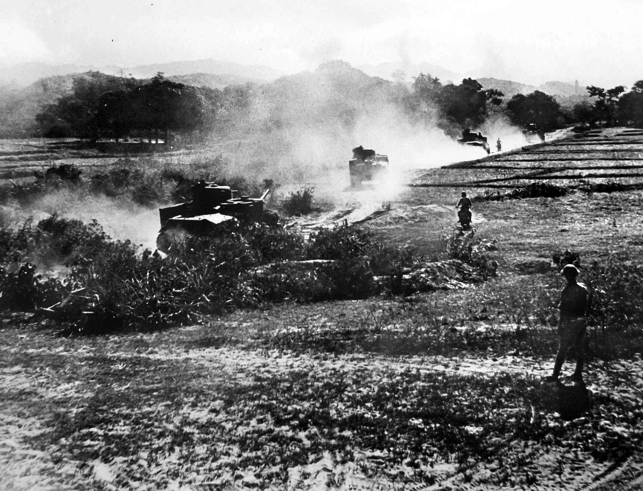 British armored crews advance against Japanese positions in American-supplied M3 Lee medium tanks during heavy fighting in the Burma Campaign. Their high profile and side-mounted 75-mm hull guns made them a liability in the European theater, but their thick armor and crushing firepower were highly effective in jungle combat, allowing Allied forces to blast open heavily fortified Japanese bunkers that had previously held up infantry advances.