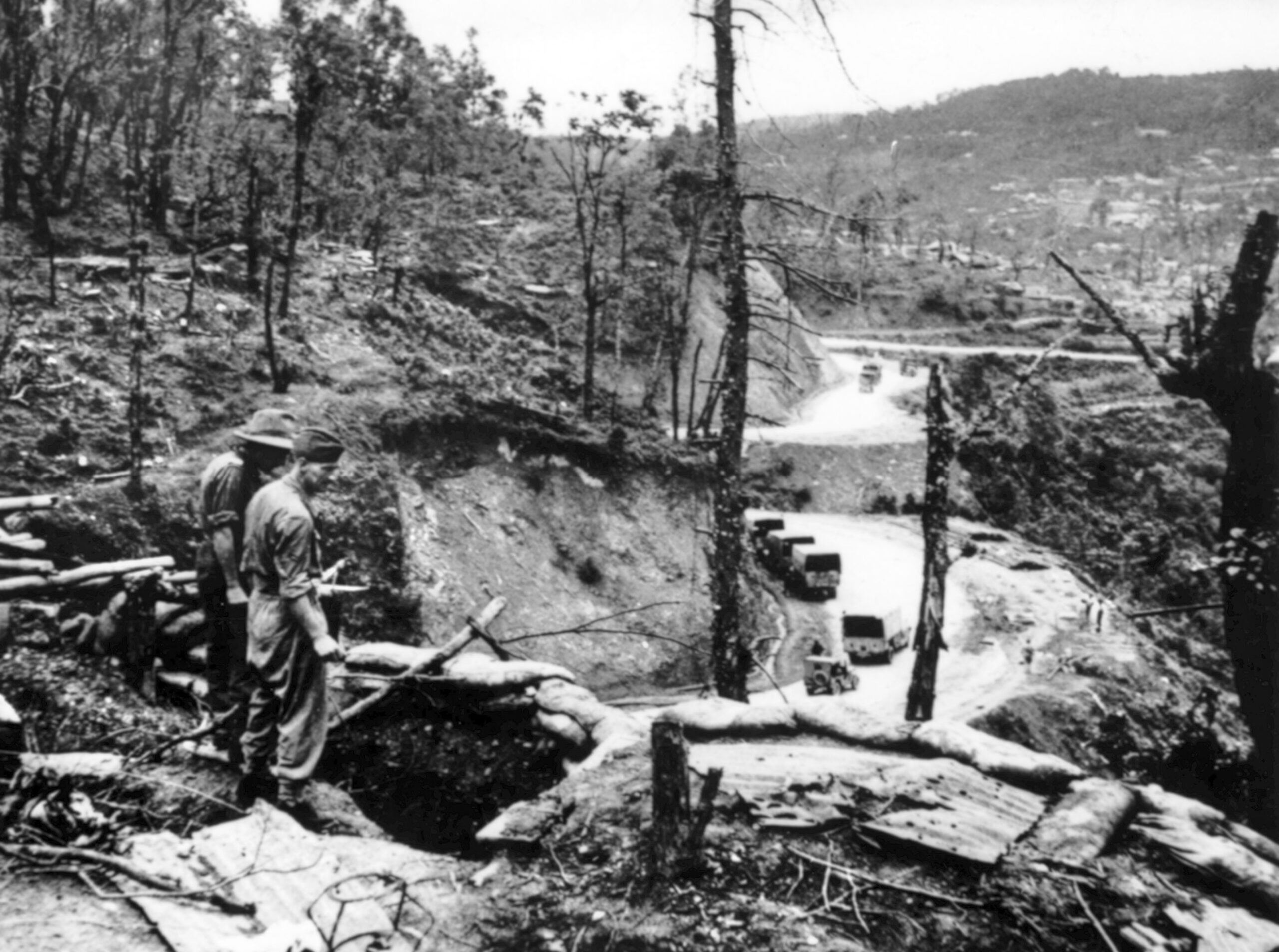 Commonwealth soldiers beside the frontline trenches along DIS (Daily Issue Store) Ridge near Kohima, with the elevated silhouette of Naga Village visible in the distance. Part of the core defensive perimeter, this sector saw some of the most intense close-quarters combat of the siege as Allied troops held the line against unrelenting Japanese assaults.