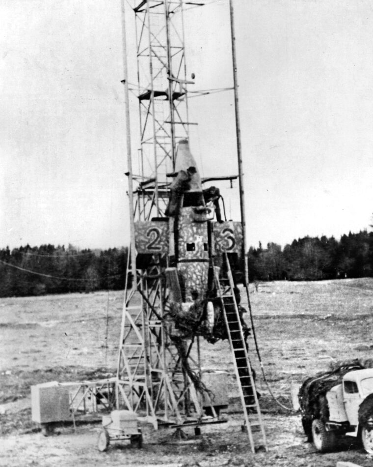 Technicians prepare a Natter prototype mounted on its vertical launch tower. Constructed primarily of non-strategic timber, the rocket bypassed the need for traditional airfields, relying on simple wooden rails for liftoff.