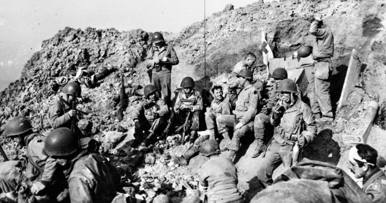 Rangers of the 2nd Battalion pause inside a bomb crater atop Pointe du Hoc on the coast of Normandy. After scaling the cliffs, searching out the relocated artillery, and destroying the guns, the Rangers maintained their isolated perimeter for two days until relief forces arrived from Omaha Beach.