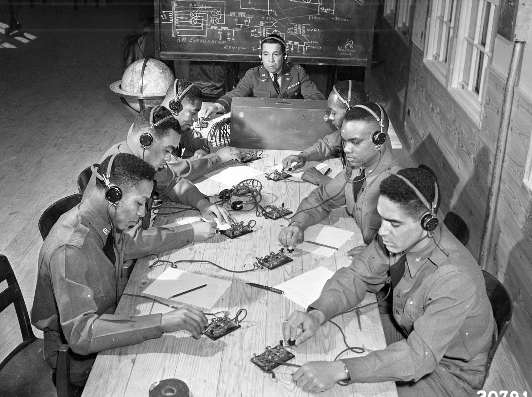 Tuskegee cadets practice Morse code and radio communications during ground school instruction. Among them is Sherman W. White Jr. (circled), who was shot down over Sicily on July 2, 1943, becoming the first African American fighter pilot killed in combat.