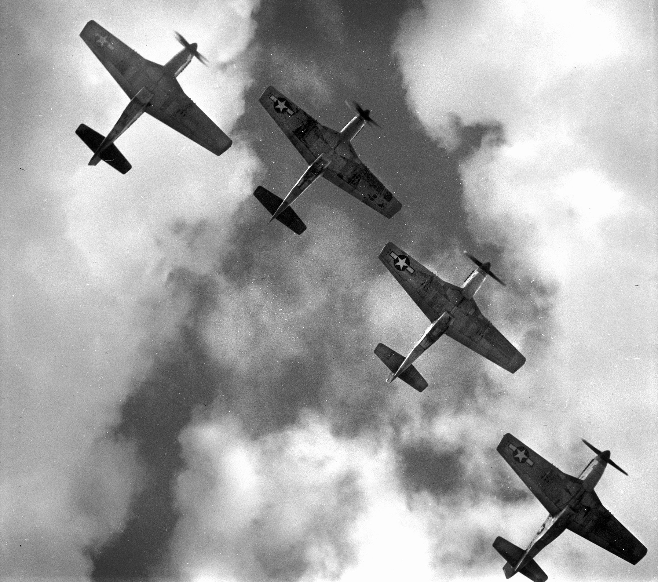 P-51 Mustangs of the 332nd Fighter Group fly over Ramitelli Airfield near Campobasso, Italy, in March 1945. After initial combat tours in P-40 Warhawks, the Tuskegee Airmen of the 332nd Fighter Group transitioned to P-47 Thunderbolts and later the long-range P-51 Mustang, establishing a distinguished record escorting Allied bombers over Europe.