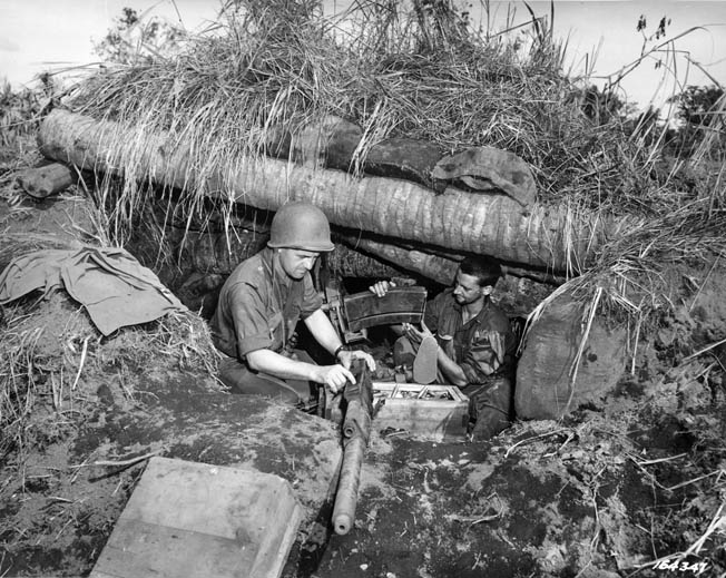 Soldiers of the 32nd Infantry Division maintain their machine gun from a reinforced position in the New Guinea jungle. American firepower and supply gave them a decided advantage in the upcoming fight at the Driniumor River.