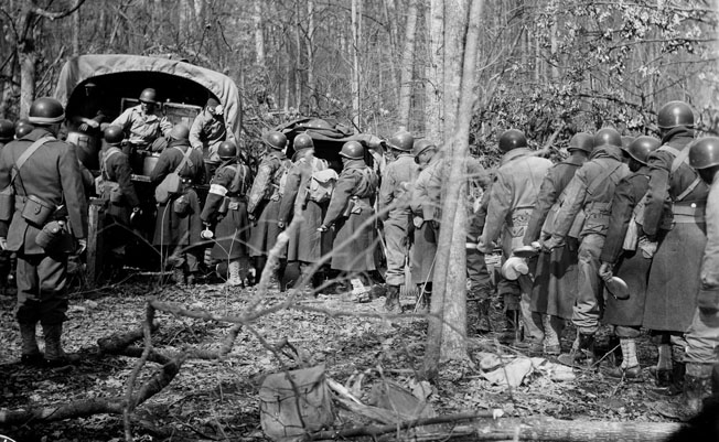 While training in the U.S. in 1943, an African American artillery battalion lines up for chow in the field. Both in training and in combat, units were strictly segregated. 