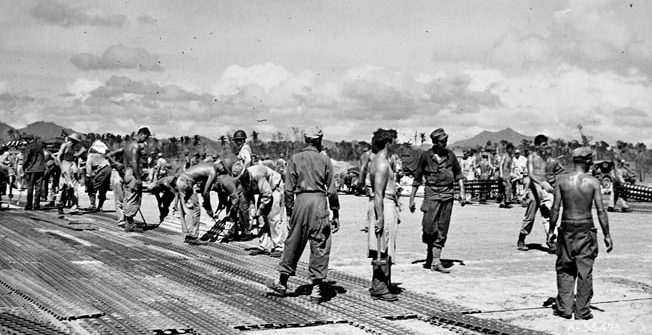 Combat engineers installing Marsden Matting, a perforated steel runway material. After landing on northern Leyte in October 1944, construction crews began building the Tacloban airstrip from which air attacks could be launched. 