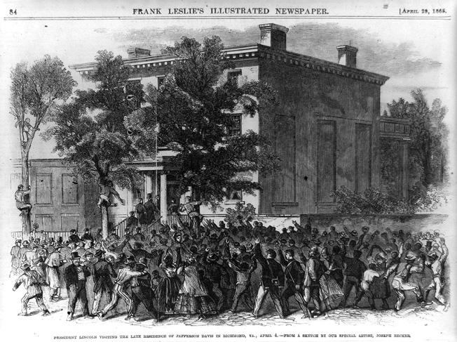 President Abraham Lincoln, accompanied by a throng of black and white supporters, enters the Confederate White House, where he would try out Jefferson Davis’s former chair. 