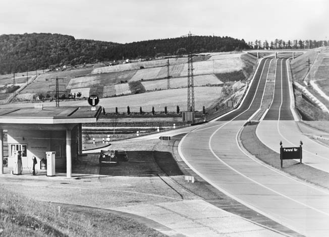 In this photograph snapped during the 1930s, a section of the modern Autobahn stretches into the distance across the German countryside. Note the service station at left. 