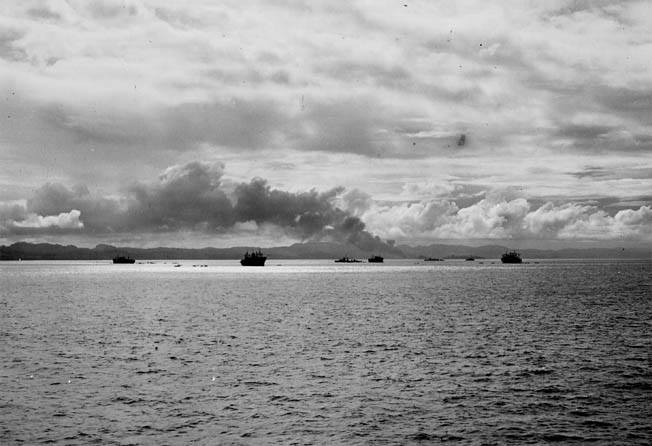 Smoke from the naval shelling rises from Gavutu Island as transports transfer troops into landing barges. Photo taken from the heavy cruiser Chicago (CA-29).