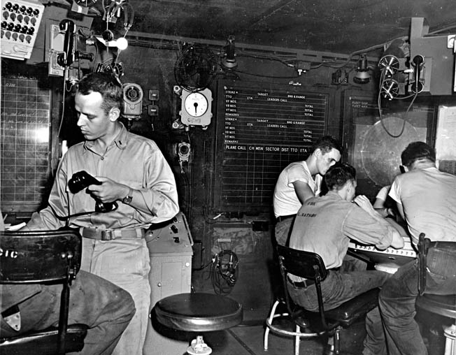 On the alert for approaching aircraft, an officer and enlisted sailors man the carrier’s radar plot during the invasion of Leyte, November 1944.