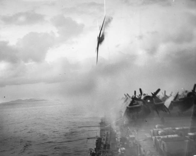 The escort carrier USS Sangamon (CVE-26), operating near Okinawa, survives a near-miss by a <a href=