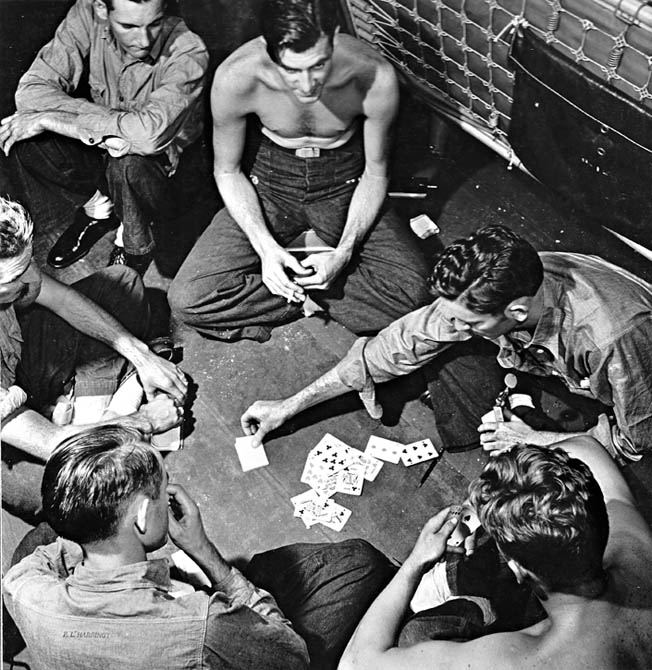 Killing time between battles, Yorktown crewmen play cards. 