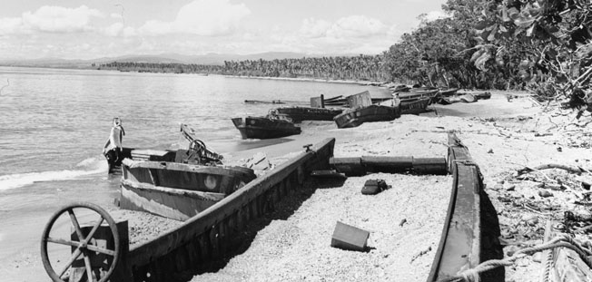 The wreckage of Japanese landing barges rusts in the sun on the beach near Cape Esperance at Guadalcanal. Japanese vessels were ravaged by American aircraft during the withdrawal of enemy troops from the island, which was declared secure by the Americans in February 1943.