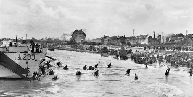 With the beachhead relatively secure, second-wave troops of the Highland Light Infantry, 9th Canadian Infantry Brigade disembark with bicycles from LCI(L)s (Landing Craft Infantry, Large) onto Juno Beach, “Nan White” Sector, at Bernières-sur-Mer, shortly before noon on June 6.