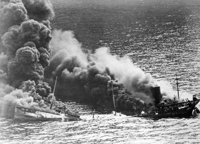 Its back broken, an oil tanker bound for Britain billows smoke as it sinks into the depths of the Atlantic Ocean. German submarines torpedoed Allied shipping at an alarming rate during Operation Drumbeat, forcing the U.S. Navy to employ new methods of antisubmarine warfare to keep the tenuous supply line open.