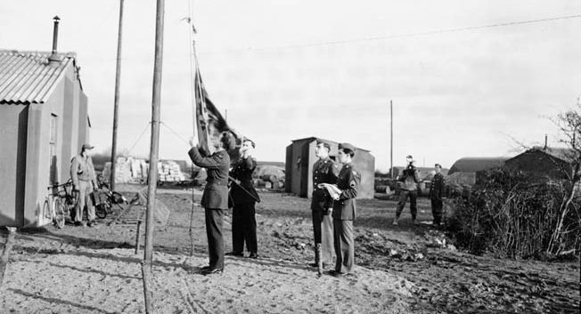 United States Army Air Forces personnel replace the British Union Jack with the U.S. Stars and Stripes after taking over the former Royal Air Force base at Bedford, England, in 1942. Bib Bowers arrived in Bedford in 1944 to begin his tour of 30 bombing missions over Nazi-occupied Europe.