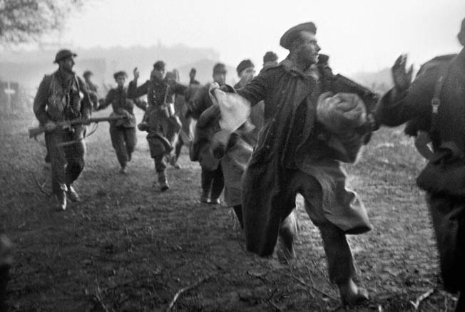 British assault troops round up German soldiers after the Allied invasion of Walcheren Island at dawn on November 1, 1944. The objective of the landing was to silence German guns guarding the Scheldt passage to the port of Antwerp.