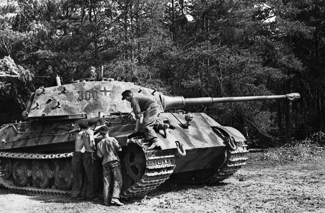 This PzKpfw. VI Tiger II sits at the edge of a French forest in June 1944, while crewmen appear to be changing the camouflage scheme. Although its 88mm high-velocity cannon was formidable, the tank was heavy, ponderously slow, and prone to mechanical failure in cross-country operations. 