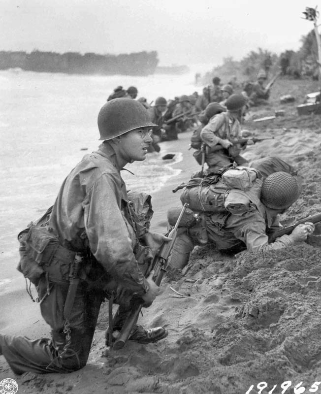 American soldiers of the 32nd Infantry Division slog through a river while on patrol in the Aitape region of New Guinea. American offensive action cut off a sizable Japanese force, and the fight at the Driniumor River ensued.