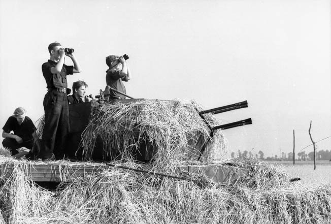 Germans man a camouflaged Flakpanzer IV Wirbelwind (“Whirlwind”), a self-propelled antiaircraft gun outfitted with a 2cm Flakvierling 38 auto cannon, at the air base in St. Malo, summer 1944. 