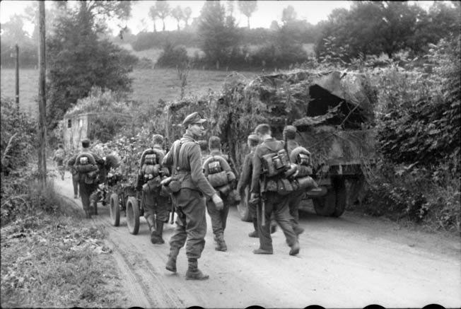 German troops advance toward the town of Breville, France, a week after the Allied invasion. British tanks and infantry failed to take and hold the town, and subsequently the Canadian paratroopers of the 1st Battalion joined in to secure the important objective. 