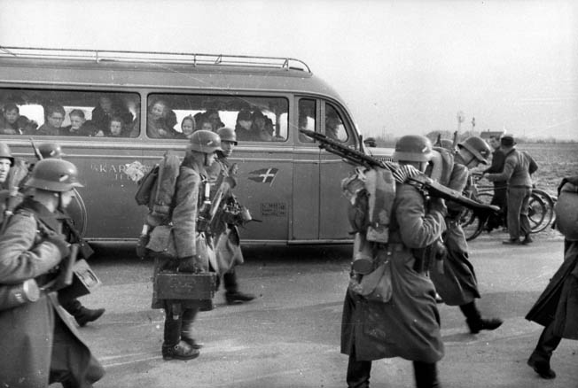 A busload of Danish school children watch in amazement as German troops march into Copenhagen, April 9, 1940. Danish defenses were overrun by the Germans in a matter of hours.