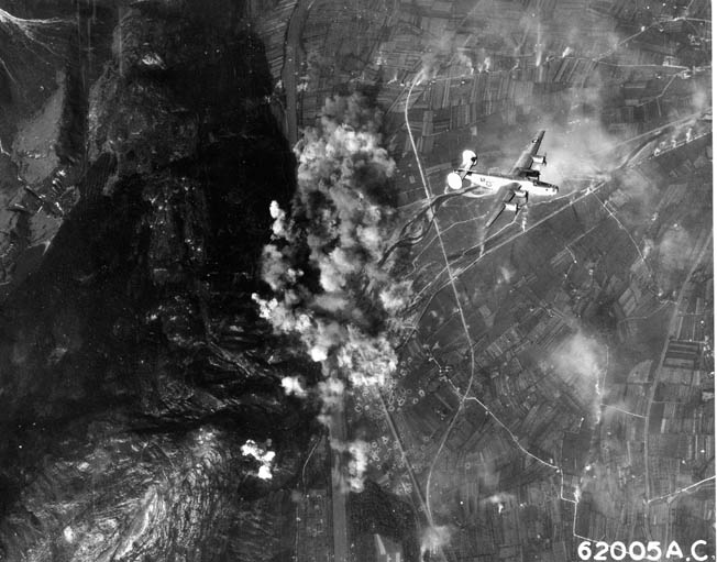 Smoke and dust rise as a B-24 Liberator flies high above a target during a raid over Germany. B-24s dropped over 450,000 tons of bombs on Europe during World War II.