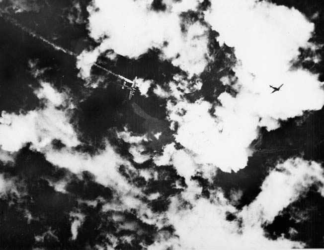 A B-24, its left outboard engine on fire, begins its fatal plunge. A Focke-Wulf FW-190 can be seen at right. Boam and his crew mates had to bail out of his stricken plane, Little Eva, near Hagenau, Alsace-Lorraine, on July 31, 1944. Boam was soon captured.