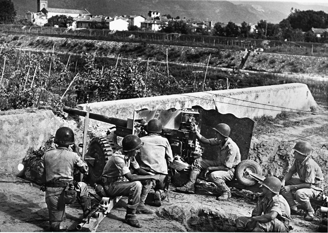A BEF gun crew mans a 57mm antitank gun and watches for enemy action, September 1944. 