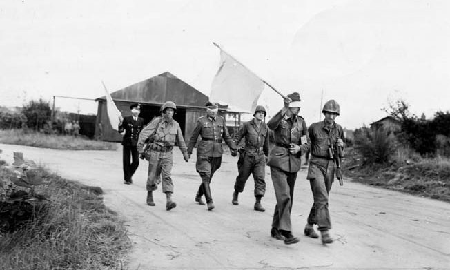 Blindfolded German officers are guided back to their lines after discussing surrender terms with American commanders, September 1944. 