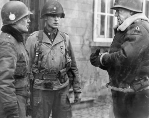 General George S. Patton (right) congratulates Brig. Gen. Anthony McAuliffe, the temporary commander of the 101st Airborne Division, and Lt. Col. Steve Chappius, the commander of 2nd Battalion, 502nd Parachute Infantry Regiment. General Patton gave them both Distinguished Service Crosses for successfully defending Bastogne. 