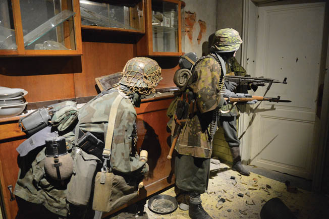 One of the realistic dioramas depicts three SS soldiers on the alert in a Belgium home.