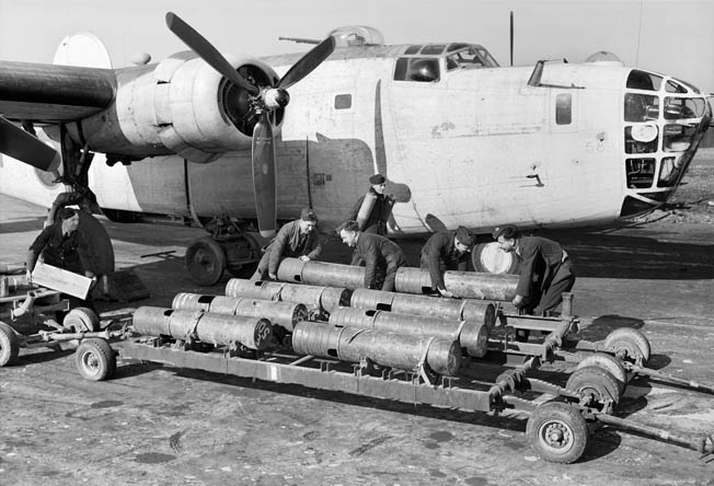 Royal Air Force armorers load 250-pound Mark VIII depth charges aboard a Consolidated Liberator Mark VA bomber of RAF Coastal Command. This aircraft is from No. 53 Squadron based at St. Eval.