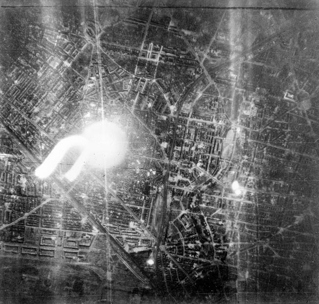 A target indicator, shown at left in this photo, illuminates the Schoneburg District of the Nazi capital of Berlin during a raid by 27 De Havilland Mosquito bombers conducted in September 1944. 